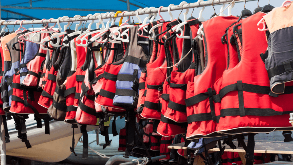 Row of various life jackets for sailing hanging on a rail