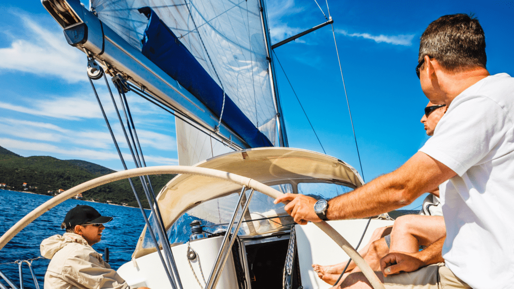 Up close of three men sailing on a white boat in open water