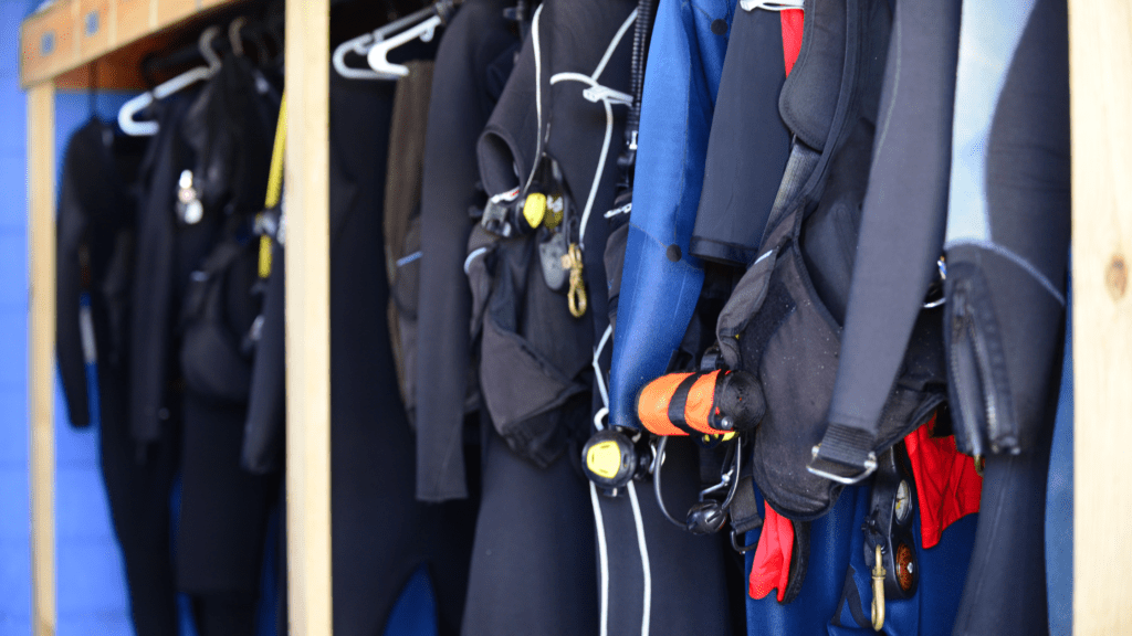 Up close image of a row of wetsuits hanging up