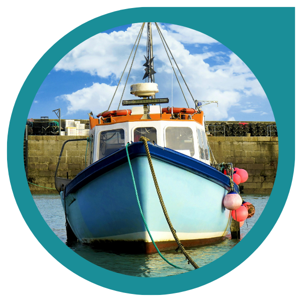 fishing boat facing the camera front on with a harbour in the background